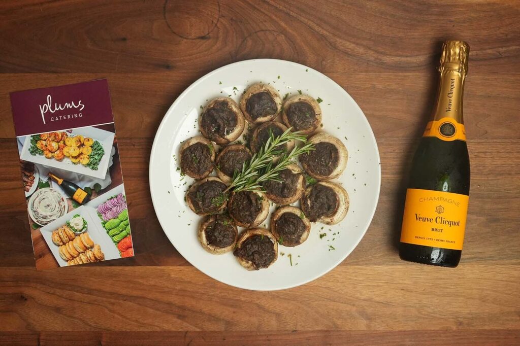 Stuffed mushroom platter with champagne bottle and catering brochure