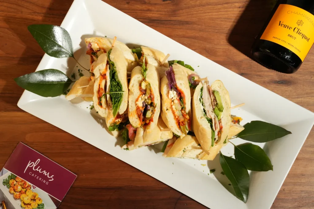 Gourmet sandwich platter served beside a bottle of champagne
